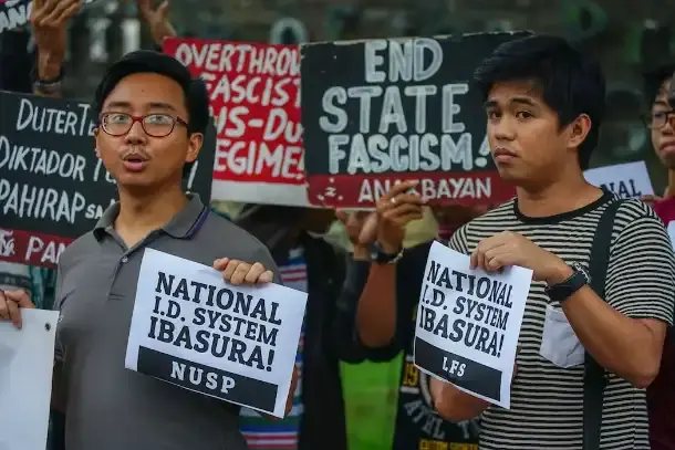 Student protesters holding signs reading National I.D. System Ibasura