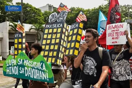Farmers' rights advocates marching with a Pax Silica effigy and a sign reading Lupa sa magsasaka, hindi sa dayuhan